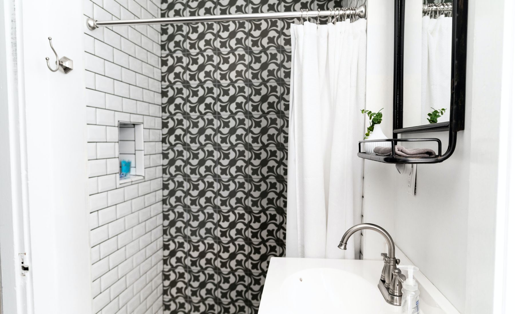 Subway tile shower with a patterned accent wall
